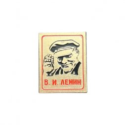 Значок В. И. Ленин в кепке. Смотрит прямо, машет рукой